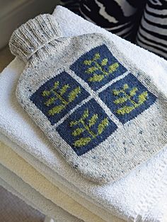 towels are stacked on top of each other in front of a window sill with two blue and white sweaters