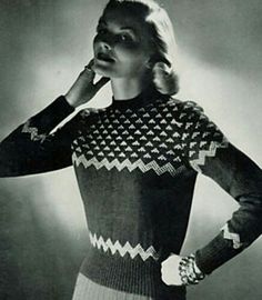 a black and white photo of a woman with her hands on her hips, wearing a sweater