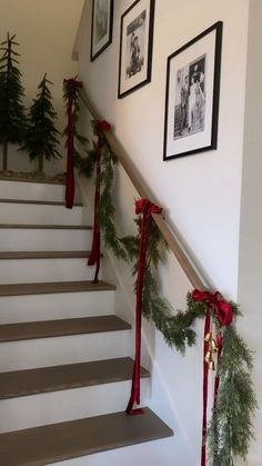 christmas garland on the banisters and stairs decorated with pine cones, red ribbon and bells