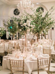 an elegant wedding reception with white flowers and greenery