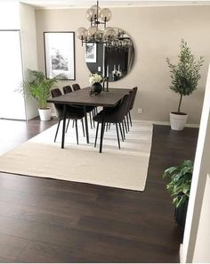 a dining room table with chairs and a rug on the floor in front of it