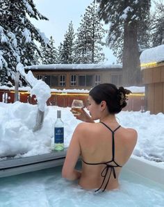 a woman sitting in a hot tub drinking wine