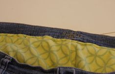 a pair of blue jeans with yellow and green designs