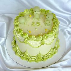 a white cake with green frosting and bears on top