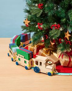 a toy train with presents under a christmas tree