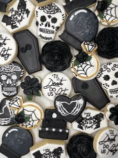 decorated cookies with black icing and white frosting are arranged in the shape of skulls