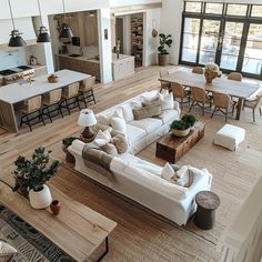 an aerial view of a living room and kitchen area with couches, coffee table, dining chairs, and open floor plan