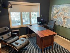 an office with two leather chairs and a desk in front of a large map on the wall