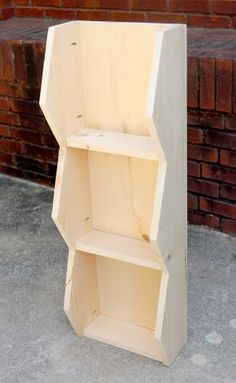 a wooden shelf sitting on top of a cement floor next to a brick wall,