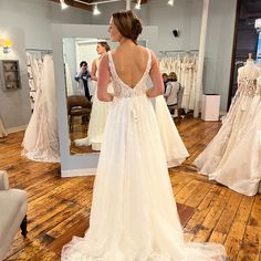 a woman is looking at her wedding dress in the mirror