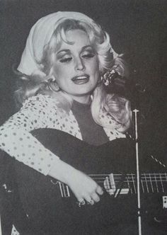 an old photo of a woman playing a guitar