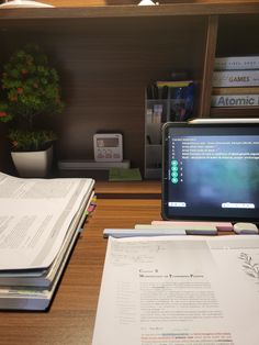 an open book sitting on top of a desk next to a computer monitor and keyboard