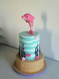 a pink dolphin on top of a blue and white cake