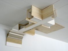 an unfinished ceiling with wooden beams and blinds on the top, above it is a white wall