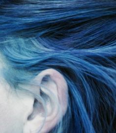 a woman with blue hair and piercings on her ear