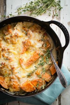 a casserole with meat and cheese in a black pan on a blue napkin