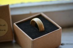 a wooden ring sits in a box on the floor