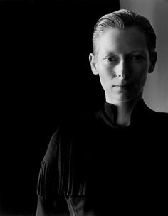 a black and white photo of a woman with short hair wearing a shirt that has fringes on it