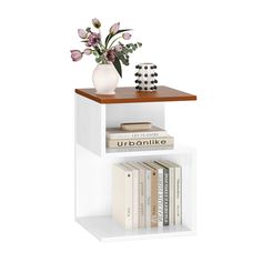 a white book shelf with books and a vase on top, sitting next to each other