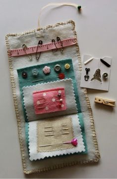 a piece of fabric with buttons and pins attached to it, next to some crafting supplies