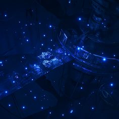 an aerial view of a building at night with blue lights on the floor and stairs