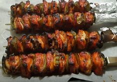 several skewers of meat wrapped in tin foil