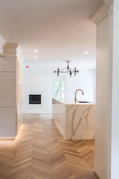 an empty kitchen with wood flooring and white walls