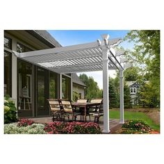 an outdoor dining table and chairs under a white pergolated patio cover with flowers in the foreground