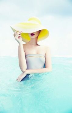 a woman in a yellow hat is sitting in the water