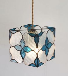 a blue and white lamp hanging from a ceiling