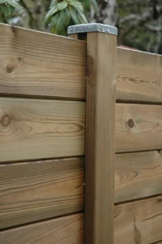 the corner of a wooden fence with a metal post