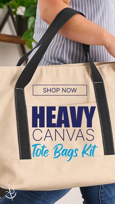 a woman carrying a tote bag that says heavy canvas the bags kit on it