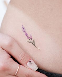 a woman's stomach with a small flower tattoo on it