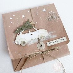 a small card with a car and christmas tree on the top, tied in twine