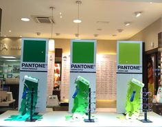 three display cases with green and white designs on them in a retail store's window