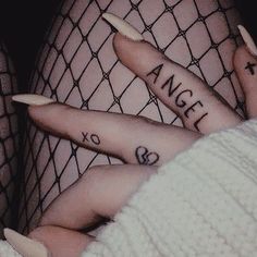 two people with tattoos on their fingers and one has the word angel tattooed on them