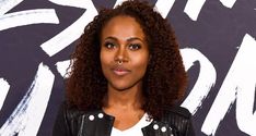 a close up of a person wearing a black jacket and white shirt with an afro