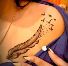 a woman's back with birds and a feather on it