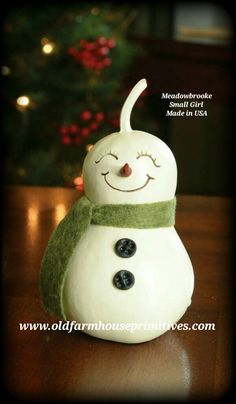 a white snowman sitting on top of a wooden table