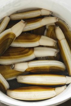 there are several bananas in the water and one banana is on the other side of the bowl