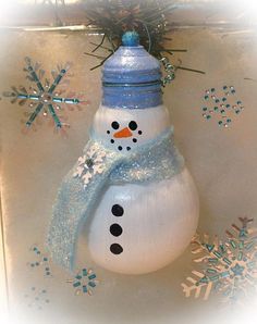 a snowman ornament hanging from a christmas tree with blue and white decorations