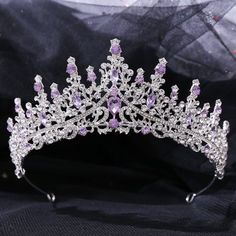 a tiara is shown on a black cloth with white and pink stones in the center