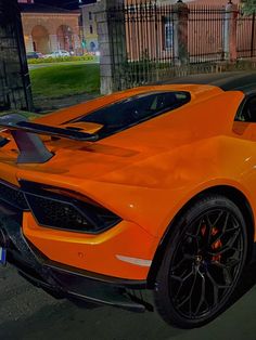 an orange sports car is parked on the street