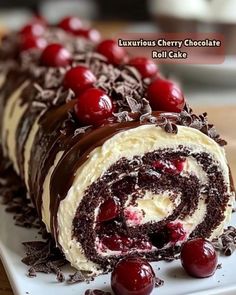 a roll cake with chocolate and cherries on it