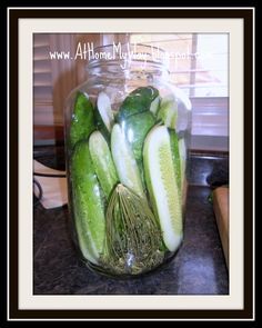 cucumbers are in a glass jar on the counter