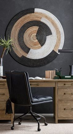 a chair sitting in front of a desk with a painting on the wall behind it