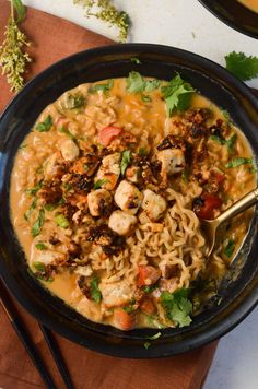 a black bowl filled with noodles and meat