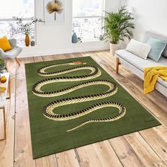 a green rug with a snake on it in a living room next to a couch