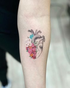 a woman's leg with a heart and flowers tattoo on it