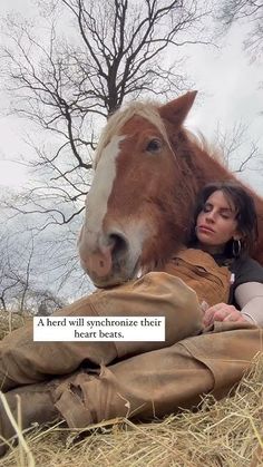 a woman laying on the ground next to a horse with a caption that reads, a herd will synconize their heart beats